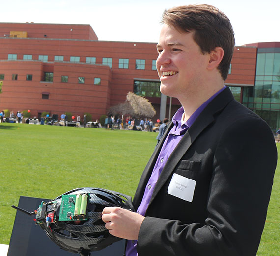 Man leans against brick wall with cherry blossom tree behind it.